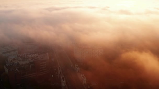 Repülj a reggeli város fölé. Korlátozott látótávolság a köd vagy az alacsony felhők és a felkelő nap miatt. Varsó, Lengyelország — Stock videók