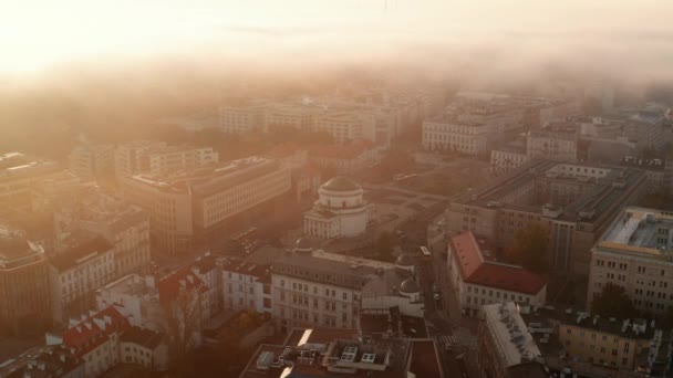 Pemandangan udara bangunan di kota di pagi hari berkabut. Terang matahari terbit emas. Gereja di Three Cross Square. Warsawa, Polandia — Stok Video