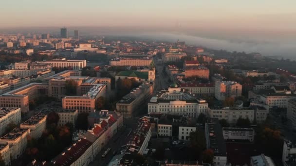 Ochtend luchtfoto van gebouwen in de stad bij zonsopgang. Mist rond rivier op de achtergrond. Warschau, Polen — Stockvideo