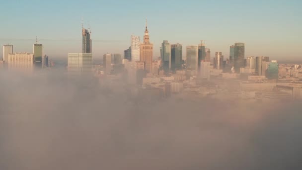 Amazing shot of downtown panorama coming out from dense fog. Group of high rise buildings lit by morning sun. Warsaw, Poland — Stock Video