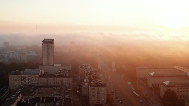 Terbang di atas jalan yang luas dan bangunan perumahan di kota. Kabut tipis berwarna-warni di waktu matahari terbit. Warsawa, Polandia — Stok Video