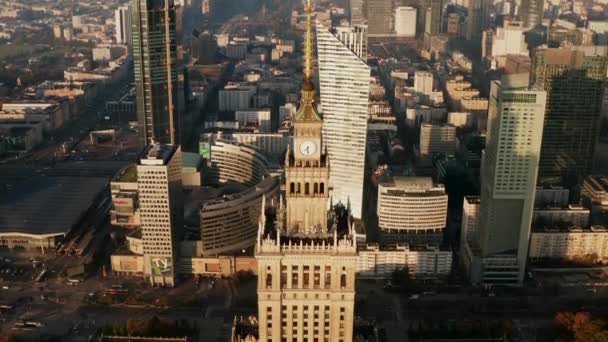 Imágenes aéreas de la torre superior del edificio PKIN con reloj de torre. Vista de ángulo alto de la ciudad en el sol de la mañana. Varsovia, Polonia — Vídeos de Stock