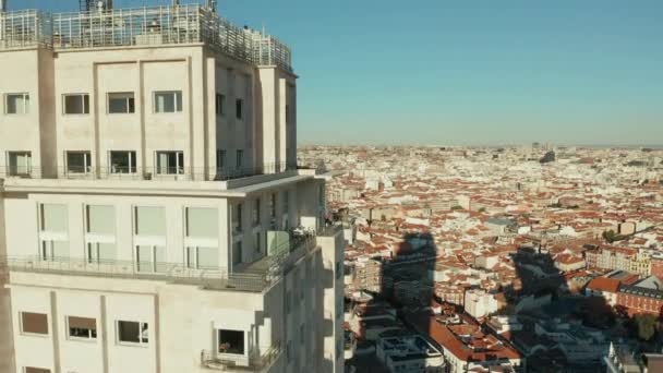 Растущие кадры высотного здания Torre de Madrid с длинной тенью на домах ниже. Наклонись на крышу. — стоковое видео