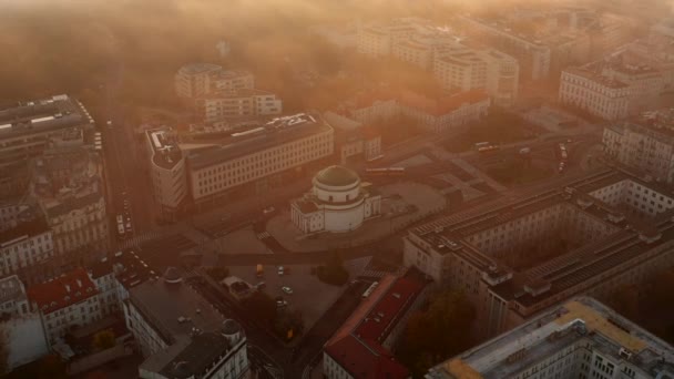 Flygfoto av kyrkan vid Three Crosses Square. Gyllene morgonsol lyser i dimma. Flyg ovanför stan. Warszawa, Polen — Stockvideo