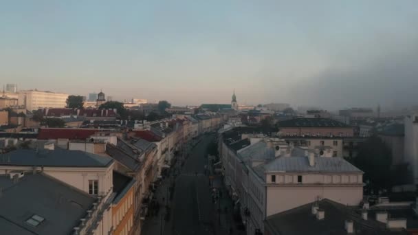 Mglisty poranek w mieście. Naprzód latają nad ulicą wyłożone kamienicami. Autobusy komunikacji miejskiej jadące po drodze. Warszawa, Polska — Wideo stockowe