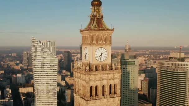 Dra tillbaka bilder av tornet klocka på toppen av hög höjd historisk byggnad i sovjetisk stil. Moderna skyskrapor i centrum i bakgrunden. Warszawa, Polen — Stockvideo