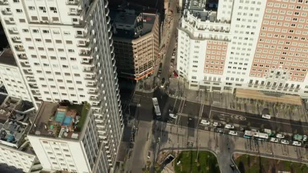 Filmagem aérea ascendente de edifícios altos em torno da Plaza de Espana à luz do sol da tarde. Tráfego rodoviário nas ruas abaixo. — Vídeo de Stock