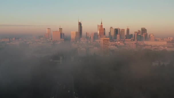 Vpřed letí nad mlhu. Panoramatické záběry vysokých budov v centru města v ranním slunci. Odhalení města. Varšava, Polsko — Stock video
