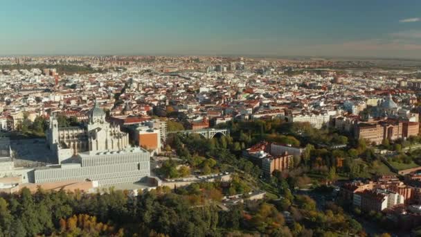 Vorwärts fliegen über den Stadtpark. Luftaufnahme einer Großstadt mit historischen Sehenswürdigkeiten. Almudena-Kathedrale über dem vom Viadukt von Segovia überspannten Tal. — Stockvideo