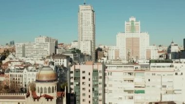 Aziz Theresa Kilisesi ve Aziz Joseph Kilisesi 'nin renkli kubbesinin etrafındaki binaların üzerinden uç. Etrafı yüksek binalarla çevrili İspanya meydanı.