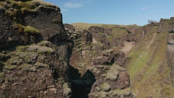 드론은 넓은 절벽 과푸른 이끼 풀 언덕 이 있는 아이슬란드 협곡을 볼 수있다. 파자 르 글로 쥬 협곡의 암석 형성을 공중에서 본 것이다. 지구 상의 아름다움. Fjadrargljuf- 협곡 — 비디오