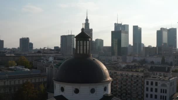 Fly around dome of Holy Trinity Church with golden cross on top. Cityscape with high rise buildings in background. Warsaw, Poland — Stock Video