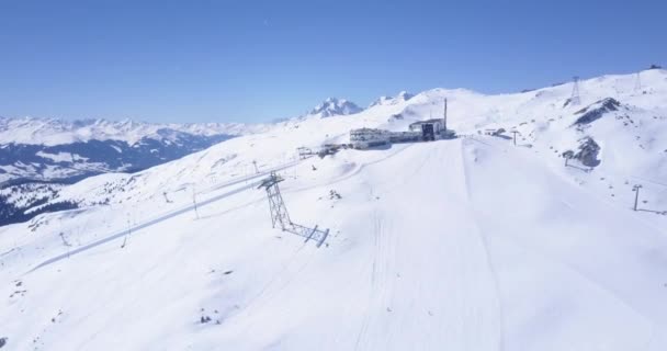 Montañas cubiertas de nieve en el soleado día de invierno con cielo despejado. Parapente por encima del complejo de deportes de invierno en los Alpes. Laax, Suiza — Vídeo de stock