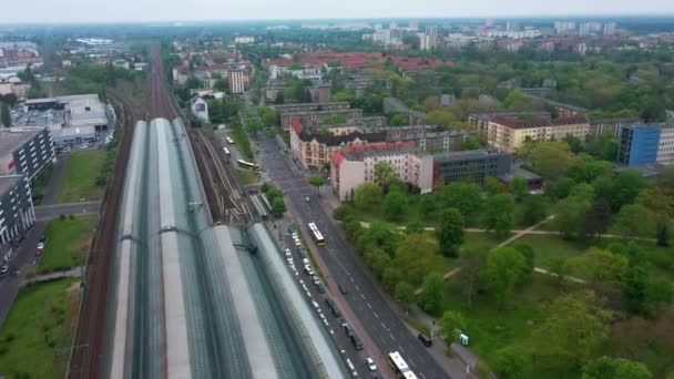 İleri, şehirdeki tren istasyonunun üzerinden uçar. Kentsel yerleşim yerlerinin havadan görünüşü. Apartman daireleri arasında ağaçlar ve parklar. Berlin, Almanya — Stok video