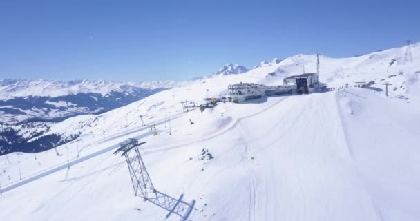 Vorwärts fliegen über steile Skihänge in winterlichen Bergen. Auf zur Bergstation mit Restaurant und Hotel am Crap Sogn Gion. Laax, Schweiz — Stockvideo
