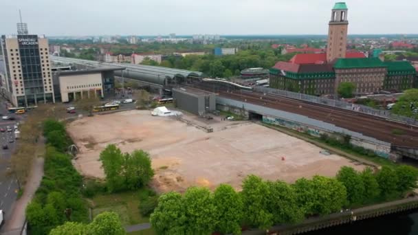 Panorama bocht schot van de vrije ruimte aan de waterkant tussen spoorlijnen en drukke weg op Spandau treinstation. Stad op de achtergrond. Berlijn, Duitsland — Stockvideo