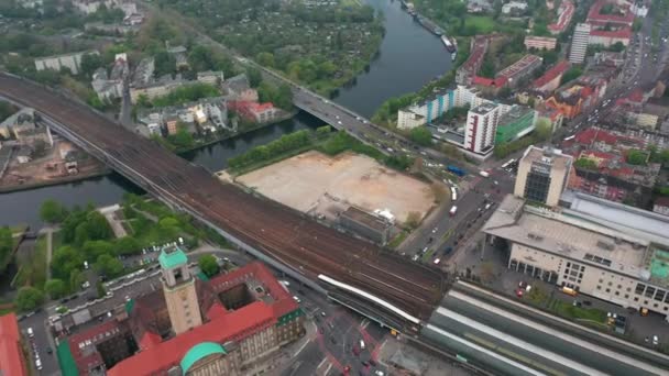 在Rathaus Spandau附近，哈韦尔河的空中拍摄流经城镇。火车站周围交通的高角度视图.德国柏林 — 图库视频影像