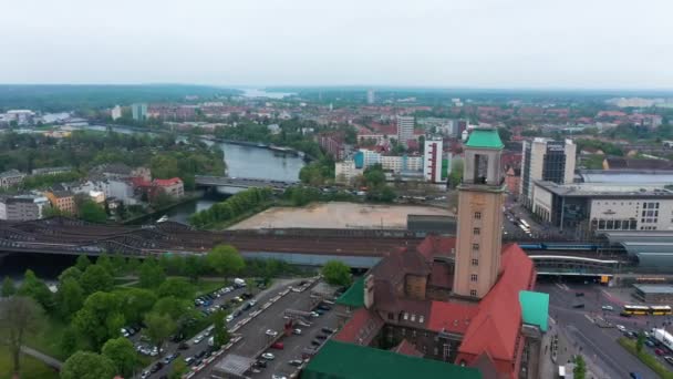 在Rathaus Spandau的高塔周围飞行。蓝色乘客城际列车离开火车站.城市的背景。德国柏林 — 图库视频影像