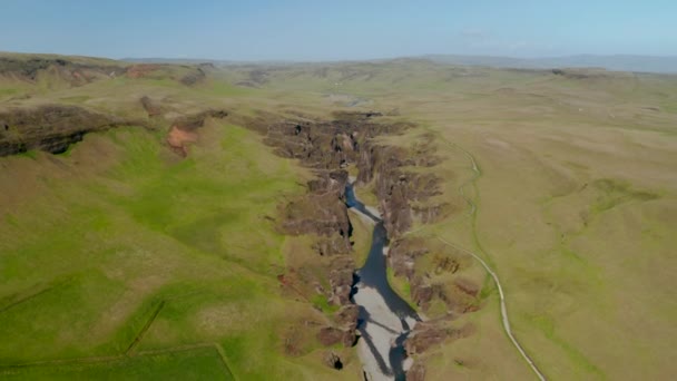 Vogelperspektive auf den Fluss Fjadra, der durch den 100 Meter tiefen Canyon Fjadrargljufur fließt. Reiseziel. Luftaufnahme der Wildnis der grün bemoosten Hügel in der Fjadrargljufur-Schlucht — Stockvideo