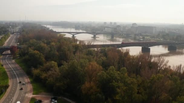 두 대의 열차가 비스툴라 강을 가로지르는 철도 다리에서 서로 스쳐 지나가고 있다. 잔잔 한 갈색 물. 폴란드, 바르샤바 — 비디오