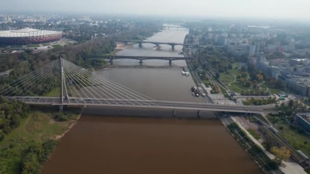 En avant voler au-dessus de la rivière. Inclinez-vous révéler rangée de divers ponts reliant la banque dans la ville. Stade national moderne sur la rive de la Vistule. Varsovie, Pologne — Video