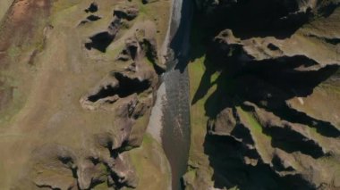 Fjadra Nehri 'nin Fjadrargljufur Kanyonu' ndan geçişi. İzlanda 'nın güneyindeki 100 metre derinliğindeki kanyonun tepesinde yosunlu yeşil tepelerden akan bir nehir var.