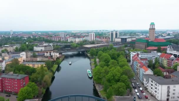 Voorwaarts vliegen boven de rivier in de stad. Treinen rijden over een brug in de buurt van het station. Appartementengebouwen in residentiële wijk. Berlijn, Duitsland — Stockvideo