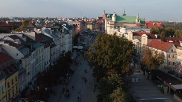 Framover turistene flyr man på Krakowskie i det historiske sentrum. Utsikt over gamle palasser og kirker. Warszawa, Polen – stockvideo