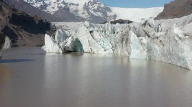 Güney İzlanda 'daki Breidamerkurjokull buzulunun yüzen buzdağının havadan görünüşü. Vatnajokull Ulusal Parkı 'ndaki buzul dili ve kar kaplı dağların insansız hava aracı görüntüsü. Breidamerkurjokull buzulu
