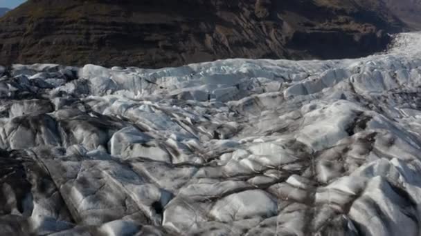 Повітряний вид льодовикової текстури на Breidamerkurjokull льодовиковій мові в Ісландії. Сценічний безпілотний вид на вкриті снігом гори. Дивовижна природа. Національний парк Ватнайокутль — стокове відео