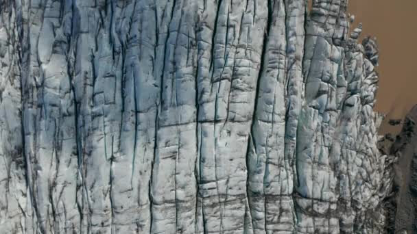 Vista dall'alto verso il basso del ghiaccio incrinato del ghiacciaio Breidamerkurjokull nel parco nazionale Vatnajokull con ghiaccio di fango marrone. Vista aerea della formazione ghiacciata del permafrost glaciale congelato nell'Islanda artica — Video Stock