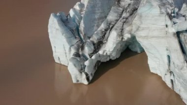 Yüzen görkemli buzdağının kuş bakışı görüntüsü, İzlanda 'da Breidamerkurjokull buzulunun dili. Vatnajokull Ulusal Parkı 'ndaki buz bloğu oluşumunun hava görüntüsü. İklim değişikliği. Doğada güzellik