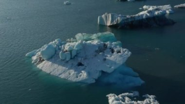 İzlanda 'da yüzen buzdağlarıyla Breidamerkurjokull buzul gölünün güzel insansız hava aracı manzarası. Buzulların eridiği ve ana buzullardan çatladığı buzul gölünün havadan görüntüsü.