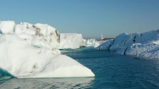 Bela vista drone paisagem fria de Breidamerkurjokull geleira lagoa na Islândia com icebergs flutuantes. Vista aérea do lago Jokulsarlon com ponte de metal no fundo — Vídeo de Stock