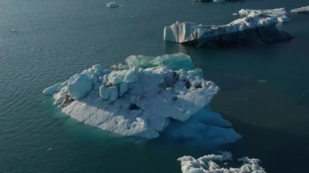 Schöne Drohnenaufnahme der kalten Landschaft der Breidamerkurjokull-Gletscherlagune in Island mit schwimmenden Eisbergen. Luftaufnahme der Gletscherlagune mit schmelzenden und rissigen Eisblöcken vom Hauptgletscher — Stockvideo