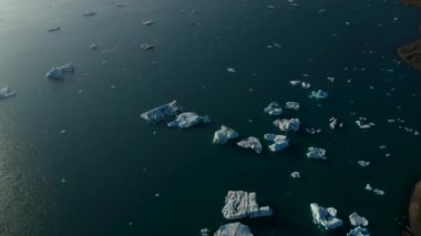 Jokulsarlon Gölü 'ndeki buz bloğu oluşumunun yukarıdan görünüşü. Vatnajokull Ulusal Parkı 'ndaki Breidamerkurjokull buzulu gölünde sürüklenen ve yüzen buzdağının en aşağı manzarası. Doğada inanılmaz.