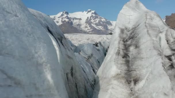 Fåglar öga drönare flyger genom spruckna spruckna isblock formationer av Breidamerkurjokull glaciär tunga på Island. Fantastisk flygbild av isberg som flyter. Vatnajokull national park — Stockvideo