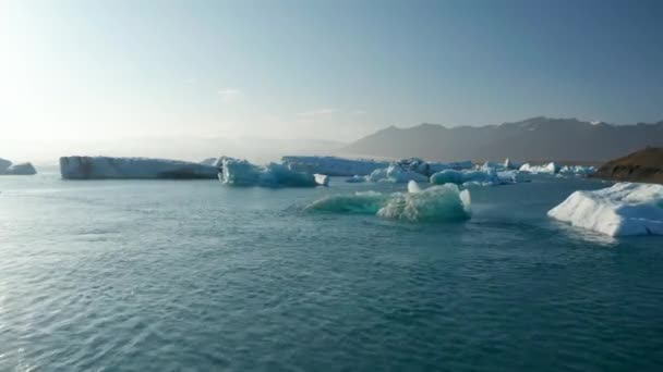 Vue panoramique sur drone lagune de glacier dans le lac Jokulsarlon, Islande, avec des icebergs flottant sur l'eau. Oiseaux vue des blocs de glace dérivant dans la lagune de Vatnajokull au-dessus de la langue du glacier Breidamerkurjokull — Video