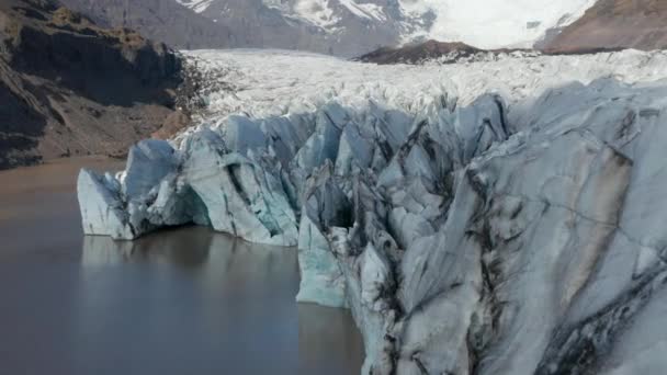 Légi kilátás úszó jéghegyek Breidamerkurjokull gleccser nyelv Izlandon. Drónkilátás hófödte hegyek és jégképződmények Vatnajokull nemzeti parkban. Breidamerkurjokull gleccser — Stock videók