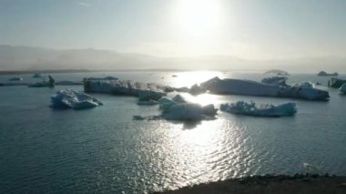 Jokulsarlon Gölü üzerinde yüzen Breidamerkurjokull buzdağının hava manzarası. İklim değişikliği. Vatnajokull Ulusal Parkı 'nın kuş gözü. Gölde buz bloğu sürükleniyor. Küresel sıcaklık