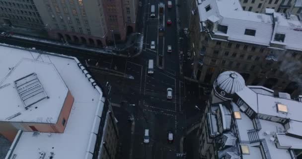 Высокий угол обзора автомобилей, проходящих через перекрёсток в городе. Улицы между снежными многоэтажными зданиями. Берлин, Германия — стоковое видео