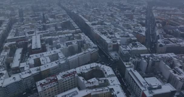 Vista de alto ángulo de calles y edificios en la ciudad de invierno cubierta de nieve. Vista panorámica aérea nebulosa. Berlín, Alemania — Vídeos de Stock