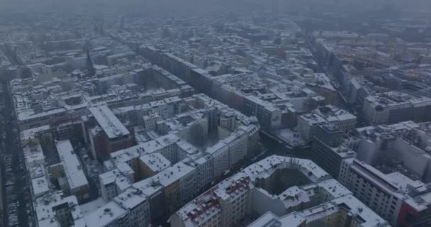 Πέτα πάνω από τη χειμερινή πόλη. Κτίρια διαμερισμάτων κατά μήκος των δρόμων στην αστική γειτονιά. Λευκές στέγες καλυμμένες με χιόνι. Βερολίνο, Γερμανία — Αρχείο Βίντεο