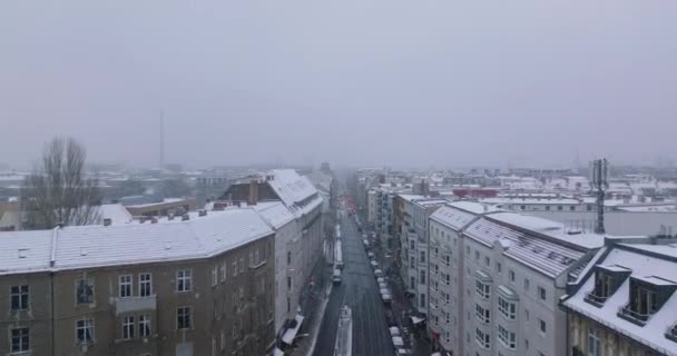 Высокие кадры зданий вдоль улицы в городском районе. Зима в городе, снегопад ограничивает видимость. Берлин, Германия — стоковое видео