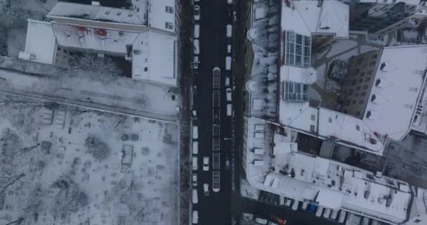 Os pássaros aéreos olham de cima para baixo a vista ascendente da rua na cidade de inverno. Rastreamento da unidade de eléctrico a funcionar nos carris. Berlim, Alemanha — Vídeo de Stock