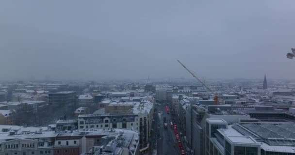 Framåt flyger över gatan i stan. Bilar står på vägen vid korsningen. Vinterstämning med snötäckta tak. Berlin, Tyskland — Stockvideo