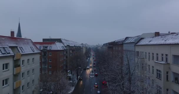 Seguimiento hacia adelante de los vehículos que conducen en la calle ancha entre casas de apartamentos de varios pisos. Invierno en la ciudad. Berlín, Alemania — Vídeo de stock