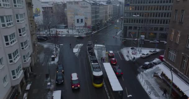 Направление движения трамвая, выходящего из стойки и проходящего через перекрёсток. Высокий угол обзора улиц города зимой. Берлин, Германия — стоковое видео