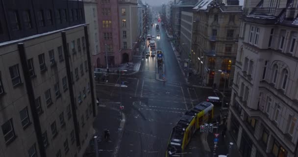Wznoszący się materiał filmowy, jak tramwaj powoli przejeżdża przez skrzyżowanie, skręca w prawo. Zimowe miasto o zmierzchu. Berlin, Niemcy — Wideo stockowe