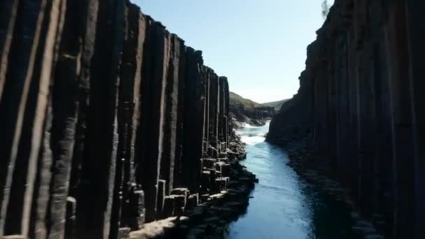 Vista drone do majestoso desfiladeiro com colunas vulcânicas de basalto na Islândia e rio de água geleira fluindo. Vista de olho de aves de canyon icelandic de Studlagil com formações de parede lavic — Vídeo de Stock